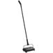 A black Lavex floor sweeper with a long pole.