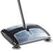 A black and blue Lavex dual blade floor sweeper with a handle.