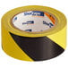 A roll of Shurtape black and yellow warning stripe tape.