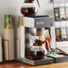 A Galaxy commercial pourover coffee maker on a counter with coffee in a glass pot.