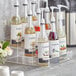 A Capora 3 tier syrup bottle organizer holding bottles of liquid on a counter.