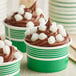 A close up of a cupcake with chocolate and white mini mochi rice cakes on top.