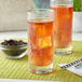 A glass of iced black tea with ice cubes.