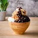 A bowl of Bossen milk snow ice with chocolate syrup and caramel drizzle.