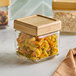 A 1-quart glass jar with a bamboo lid, filled with tri-color rotini pasta.