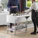 A man and woman standing in front of a ServIt cold food table on a hotel buffet.