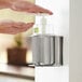 A person using a Steril-Sil stainless steel hand soap dispenser.