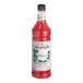 A Monin Premium Pineberry flavoring syrup bottle filled with red liquid.