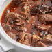 A bowl of stew with meat, vegetables, and Regal Whole Allspice on a table.