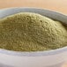 A bowl of Regal Ground Marjoram powder on a wooden table.