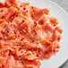 A plate of smoked salmon with Regal Pink Peppercorns on a table in a deli.