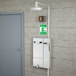 A grey Guardian Equipment safety station with a drain pan and a daylight drain on a grey wall.
