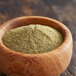 A wood bowl filled with green powder.