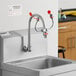 An emergency eyewash station with a faucet control valve mounted on a stainless steel sink.
