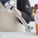 A person using an AvaMix heavy-duty blending shaft to blend a drink.