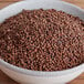 A bowl of Regal Grains of Paradise on a wooden table.