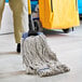 A person holding a Lavex Natural Cotton Looped End Wet Mop Head.