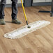 A person using a Choice natural cotton dry dust mop to clean a wood floor.