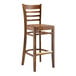 A Lancaster Table & Seating wooden bar stool with a vintage wood seat and ladder back.