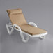 A Lancaster Table & Seating white chaise lounge with tan cushion and pillow on a white background.