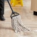 A person using a Choice Natural Cotton Wet Mop to clean a floor.