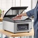 A chamber vacuum packing machine with a digital control panel and a 12-inch seal bar, shown sealing a bag of meat.