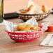 A red oval plastic basket filled with fried food.