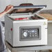 A woman using the VacPak-It Ultima vacuum packaging machine to seal meat on a counter.