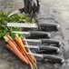 A Schraf Bird's Beak Paring Knife with a TPRgrip handle being used to peel carrots.