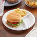 A plate of a burger and potato wedges on an Ecopax 3-compartment plate.