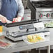 A woman in an apron uses a Galaxy vacuum packaging machine on a counter to vacuum seal tomatoes.