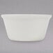 A white bone ramekin on a gray surface.