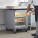 A man in a kitchen putting food into a Beverage-Air undercounter freezer.