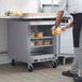 A man in a kitchen putting food into a Beverage-Air undercounter freezer.