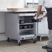 A man in a kitchen opening a Beverage-Air undercounter freezer.