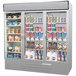 A Beverage-Air stainless steel three section glass door refrigerator with a variety of products inside.