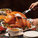 A person using a Hamilton Beach electric knife to cut turkey.