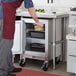 A man in a chef's uniform opening a Beverage-Air undercounter refrigerator and putting lemons in a container.