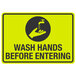 A yellow and black sign with the words "Wash Hands Before Entering" and a black and white image of a hand washing a faucet.