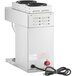 A silver Estella Caffe automatic coffee maker with a red button.