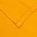 A folded rectangular yellow fabric table cover with a gold hem.