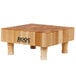 A John Boos maple wood display cutting board with legs.
