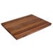 A John Boos black walnut wood cutting board with hand grips.