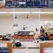 A Goff's clear PVC partition with aluminum and fiberglass bars hanging over a white counter in a convenience store.