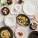 A white table set with Acopa Condesa porcelain plates, bowls, and cups.