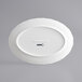 An Acopa pearl white porcelain platter with scalloped edges and a circular design on the rim.
