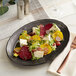 An Acopa Armor Gray scalloped porcelain platter with a beet salad with goat cheese and grapes.