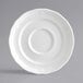 A white porcelain saucer with a scalloped edge.
