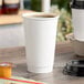 A white Choice double wall paper hot cup of coffee on a table.