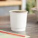 A Choice white paper hot cup filled with coffee on a table.